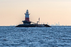 Tilted Connecticut Lighthouse in Front of City Skyline at Sunset